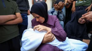Madre cdon niño en brazo en Gaza