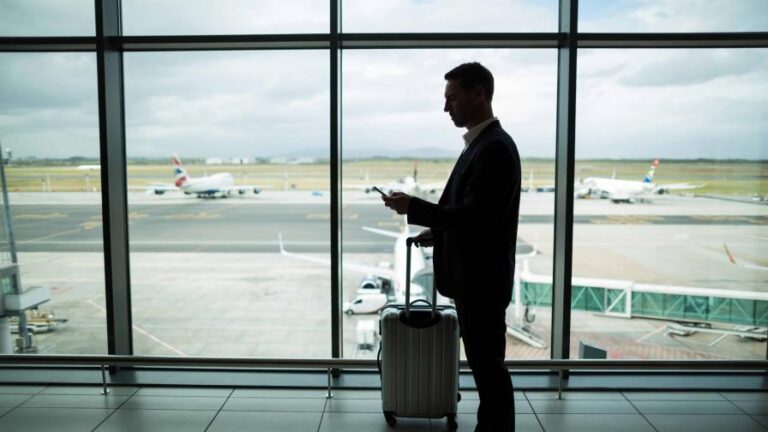 empresario-con-equipaje-mediante-telefono-movil-b42febae-focus-0.19-0.3-896-504